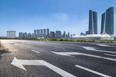 Panoramik siluet ve boş yolu, boş beton zemini olan modern iş binaları.