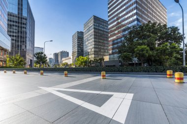 Panoramik siluet ve boş yolu, boş beton zemini olan modern iş binaları.