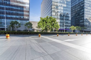 Panoramik siluet ve boş yolu, boş beton zemini olan modern iş binaları.