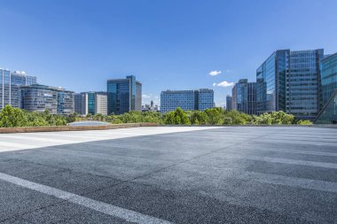 Panoramik siluet ve boş yolu, boş beton zemini olan modern iş binaları.