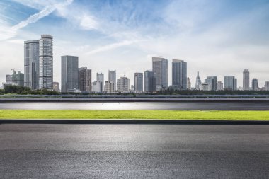Panoramik siluet ve boş yolu, boş beton zemini olan modern iş binaları.