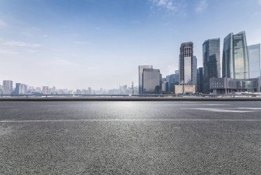 Panoramik siluet ve boş yolu, boş beton zemini olan modern iş binaları.