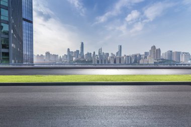 Panoramik siluet ve boş yolu, boş beton zemini olan modern iş binaları.