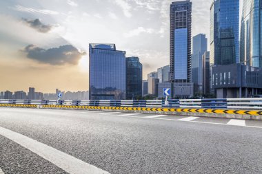 Panoramik siluet ve boş yolu, boş beton zemini olan modern iş binaları.