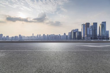 Panoramik siluet ve boş yolu, boş beton zemini olan modern iş binaları.