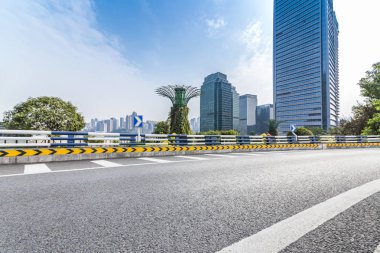 Panoramik siluet ve boş yolu, boş beton zemini olan modern iş binaları.