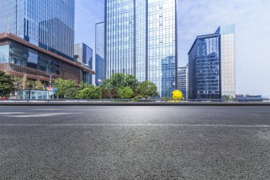 Panoramik siluet ve boş yolu, boş beton zemini olan modern iş binaları.