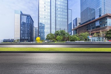 Panoramik siluet ve boş yolu, boş beton zemini olan modern iş binaları.