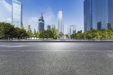 Panoramik siluet ve boş yolu, boş beton zemini olan modern iş binaları.