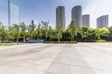 Panoramik siluet ve boş yolu, boş beton zemini olan modern iş binaları.