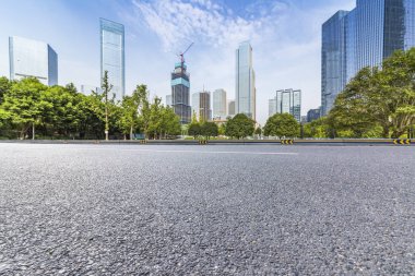Panoramik siluet ve boş yolu, boş beton zemini olan modern iş binaları.