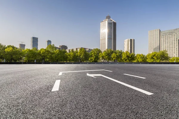Panoramik siluet ve boş yolu, boş beton zemini olan modern iş binaları.