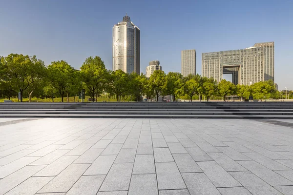 Panoramik siluet ve boş yolu, boş beton zemini olan modern iş binaları.