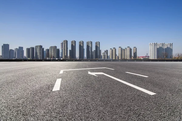 Panoramik siluet ve boş yolu, boş beton zemini olan modern iş binaları.