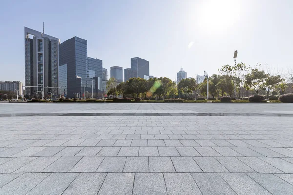 Panoramik siluet ve boş yolu, boş beton zemini olan modern iş binaları.