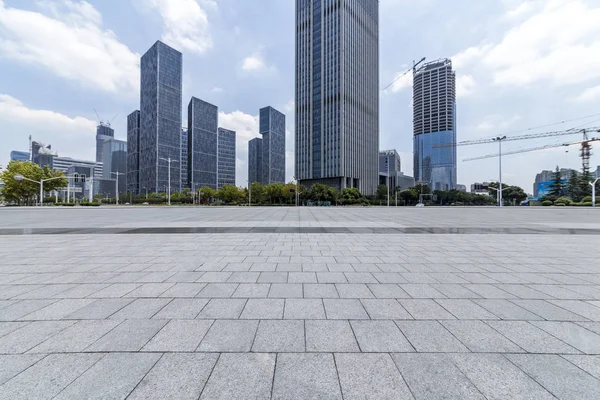 Panoramik siluet ve boş yolu, boş beton zemini olan modern iş binaları.