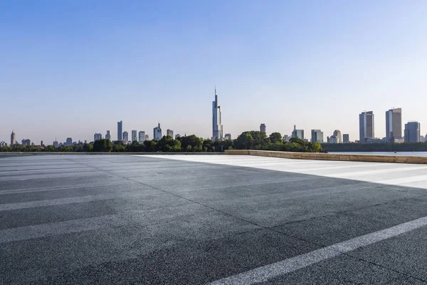 Panoramik siluet ve boş yolu, boş beton zemini olan modern iş binaları.