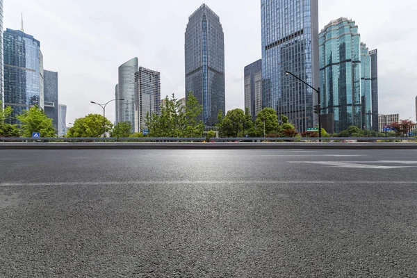 Panoramik siluet ve boş yolu, boş beton zemini olan modern iş binaları.