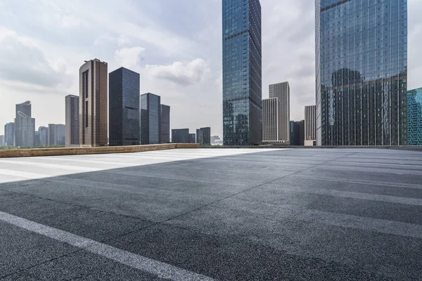 Panoramik siluet ve boş yolu, boş beton zemini olan modern iş binaları.