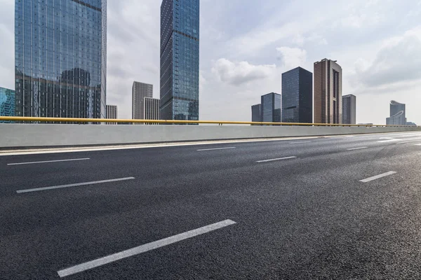 Panoramik siluet ve boş yolu, boş beton zemini olan modern iş binaları.
