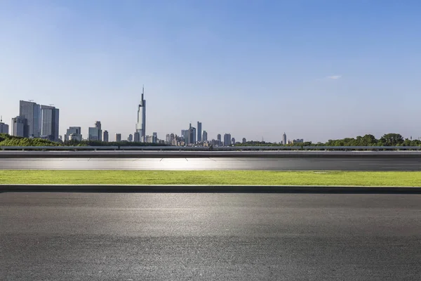 Panoramik siluet ve boş yolu, boş beton zemini olan modern iş binaları.