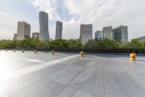 Panoramik siluet ve boş yolu, boş beton zemini olan modern iş binaları.