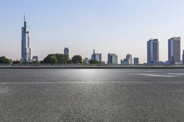 Panoramik siluet ve boş yolu, boş beton zemini olan modern iş binaları.