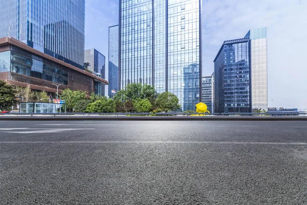 Panoramik siluet ve boş yolu, boş beton zemini olan modern iş binaları.