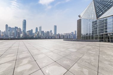 Panoramik siluet ve boş yolu, boş beton zemini olan modern iş binaları.