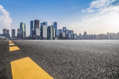 Panoramik siluet ve boş yolu, boş beton zemini olan modern iş binaları.
