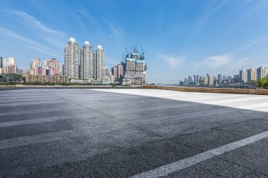 Panoramik siluet ve boş yolu, boş beton zemini olan modern iş binaları.