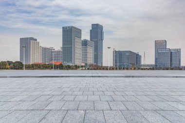Panoramik siluet ve boş yolu, boş beton zemini olan modern iş binaları.