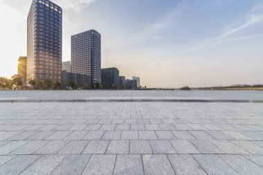 Panoramik siluet ve boş yolu, boş beton zemini olan modern iş binaları.