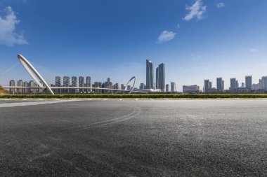 Panoramik siluet ve boş yolu, boş beton zemini olan modern iş binaları.