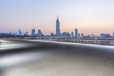Panoramik siluet ve boş yolu, boş beton zemini olan modern iş binaları.