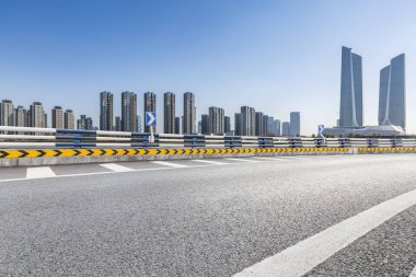 Panoramik siluet ve boş yolu, boş beton zemini olan modern iş binaları.