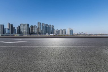 Panoramik siluet ve boş yolu, boş beton zemini olan modern iş binaları.