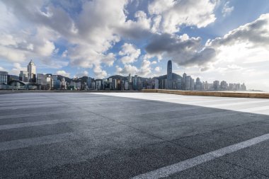 Panoramik siluet ve boş yolu, boş beton zemini olan modern iş binaları.