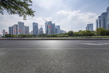 Panoramik siluet ve boş yolu, boş beton zemini olan modern iş binaları.