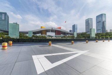 Panoramik siluet ve boş yolu, boş beton zemini olan modern iş binaları.