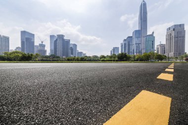 Panoramik siluet ve boş yolu, boş beton zemini olan modern iş binaları.