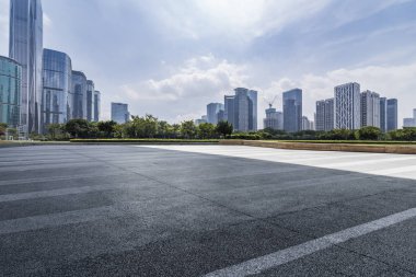 Panoramik siluet ve boş yolu, boş beton zemini olan modern iş binaları.