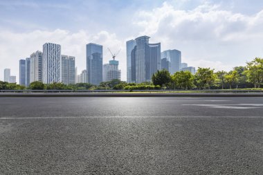 Panoramik siluet ve boş yolu, boş beton zemini olan modern iş binaları.