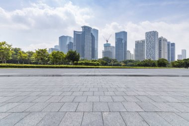 Panoramik siluet ve boş yolu, boş beton zemini olan modern iş binaları.