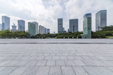 Panoramik siluet ve boş yolu, boş beton zemini olan modern iş binaları.