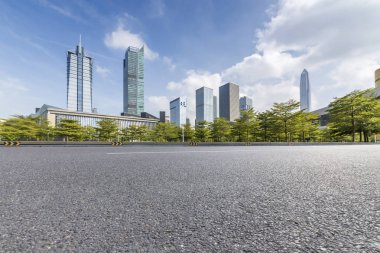 Panoramik siluet ve boş yolu, boş beton zemini olan modern iş binaları.
