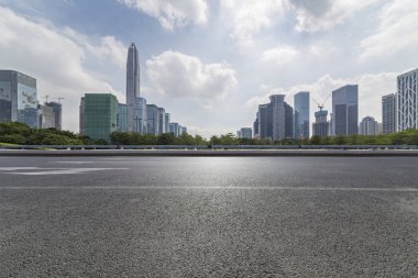 Panoramik siluet ve boş yolu, boş beton zemini olan modern iş binaları.