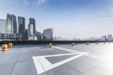 Panoramik siluet ve boş yolu, boş beton zemini olan modern iş binaları.