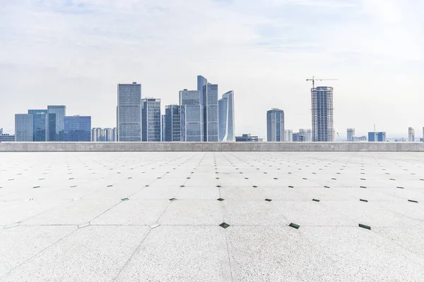 Panoramik siluet ve boş yolu, boş beton zemini olan modern iş binaları.