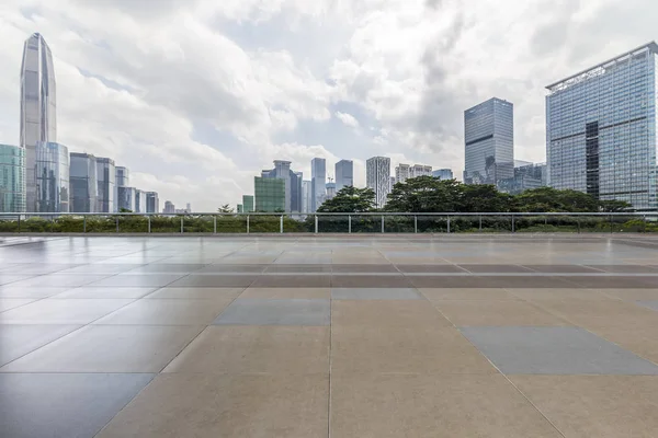Panoramik siluet ve boş yolu, boş beton zemini olan modern iş binaları.